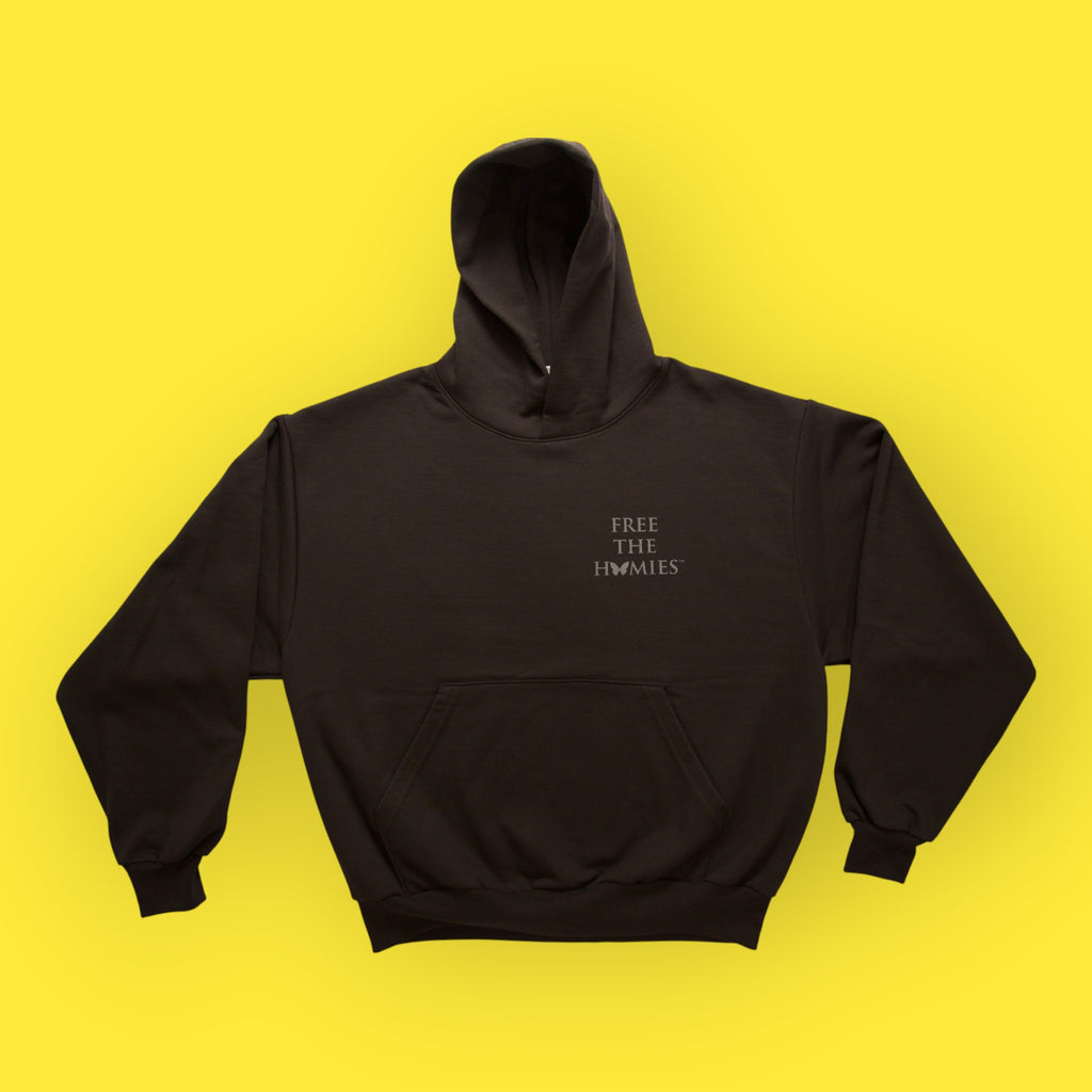 Black hoodie with 'FREE THE HOMES' text on a yellow background