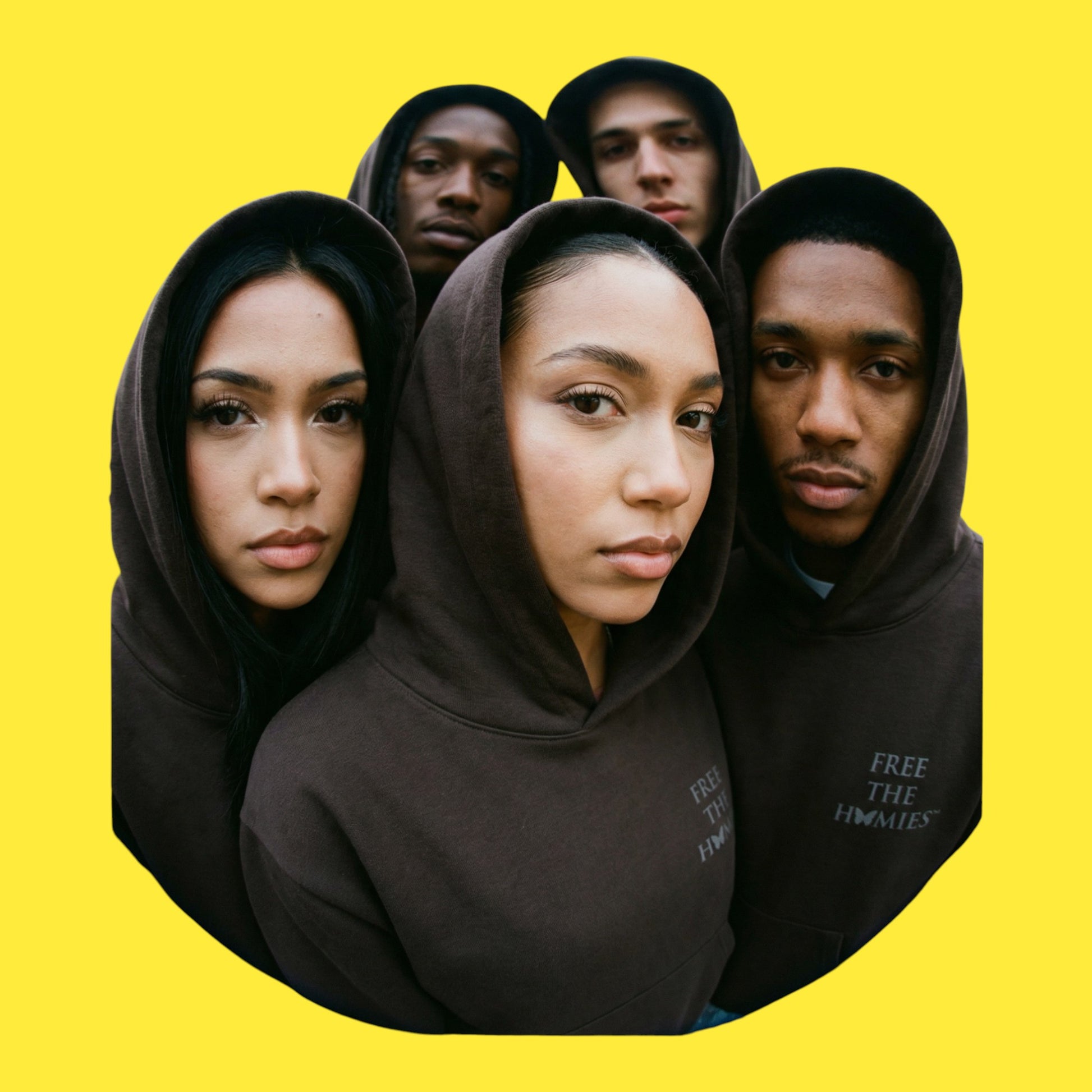 Four models wearing black hoodies with 'Free the Homies' text on the chest on a yellow background 