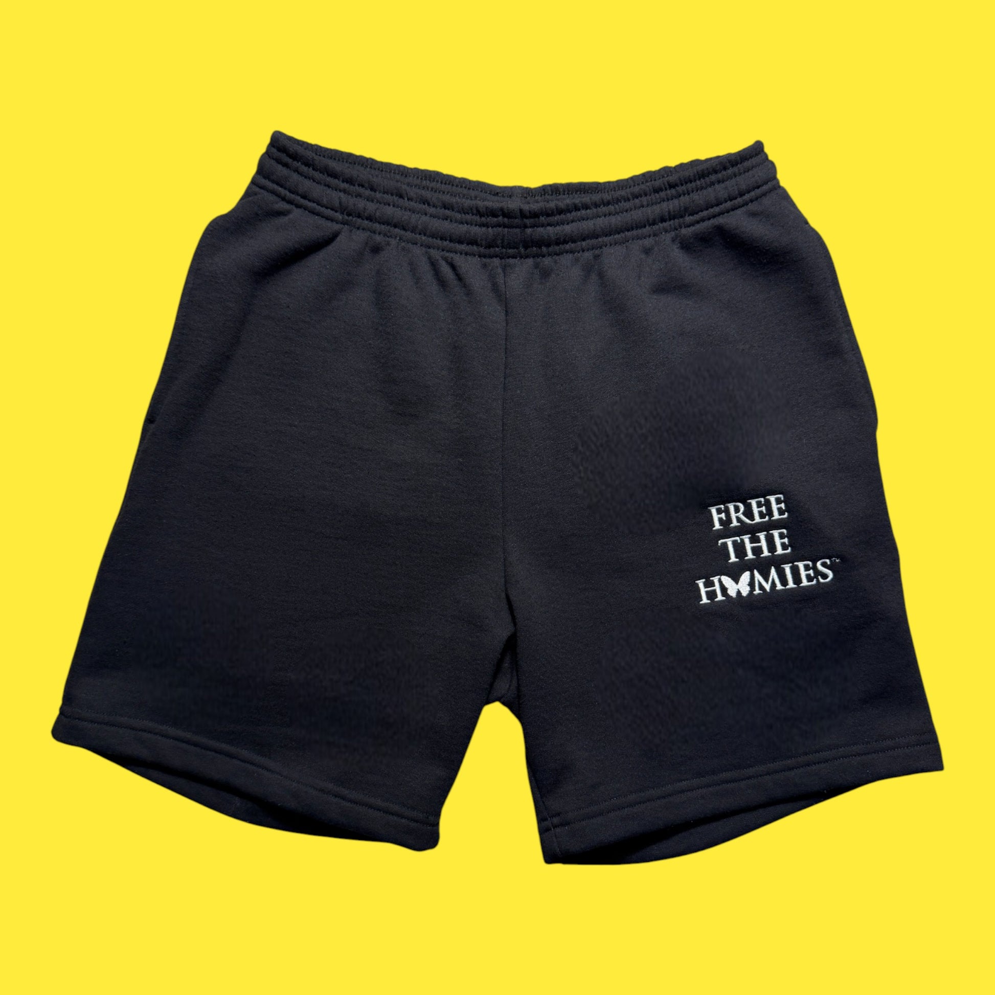 Black shorts with 'FREE THE HOMIES' text on a yellow background